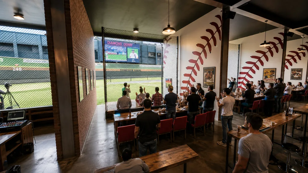 Diamond Derby cage-side lounge at sunset with screens and seating